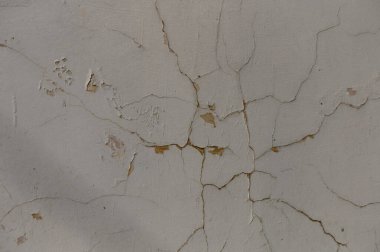 Çatlaklar alçıdan yılan gibi geçiyor, zamanın geçişini gösteriyor, eski, unutulmuş bir yapıda..