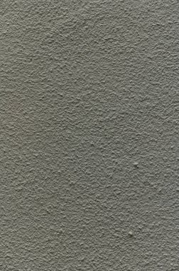 Sert gri duvar karmaşık dokuları ortaya çıkarır, sakin bir şehir ortamında merak ve yansıma yaratır..