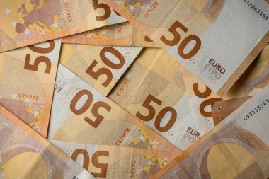 Renkli 50 avroluk banknotlar yayılarak, yumuşak ışıklandırma altında karmaşık tasarım ve canlı renklerini gözler önüne seriyor.