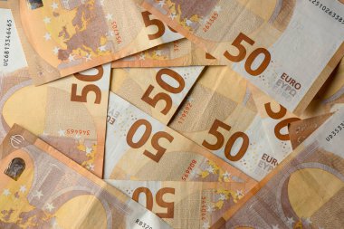Artistik olarak düzenlenmiş renkli 50 Euro 'luk banknotlar koleksiyonu, ayrıntılı desenlerini ve dokularını vurguluyor..