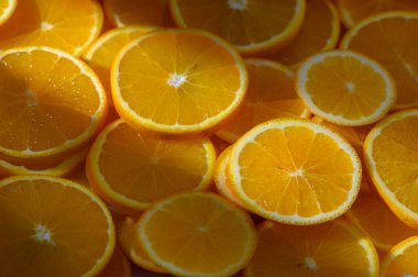 Parlak bir şekilde kesilmiş portakal dilimleri, sulu dokularını ve canlı renklerini ılık ışıkta sergiliyor..