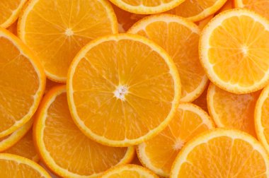 Birbiri ile örtüşen portakal dilimleri tazeliği davet eden güneşli, neşeli bir sahne yaratır..