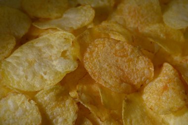 Renkli bir şekilde serpilmiş çıtır patates cipsleri herkes için enfes bir abur cubur deneyimi sunuyor..