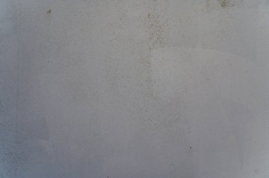 Dokulu bir duvar, sessiz renkler ve kusurların bir karışımını gösterir. Gün ışığında sakin ve sakin bir atmosferi yakalar..