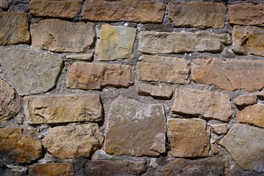 Çeşitli boyut ve renklerdeki pürüzlü taşlar dayanıklılık hikâyesi anlatan ebedi bir duvar oluşturmak için bir araya gelirler..