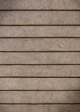 Pürüzsüz, desenli bir duvar, sakin bir ortamda minimalist bir estetiği gösteren yatay çizgiler sergiler..