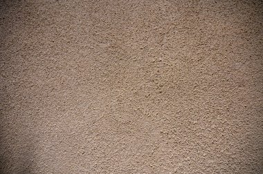 Sıcak tonlu alçı bir duvar karmaşık doku ve desenler sergiler, dingin ve doğal bir ortam yaratır..