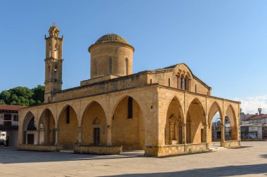 Tarihi bir taş kilise, karmaşık kemerleri ve açık mavi gökyüzünün altındaki yüksek çan kulesiyle ziyaretçileri cezbediyor..