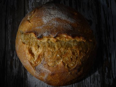 Altın kabuklu ekmek hafif ışıkta güneşleniyor, sanatsal dokusunu ve kırsal cazibesini bir anda sergiliyor..