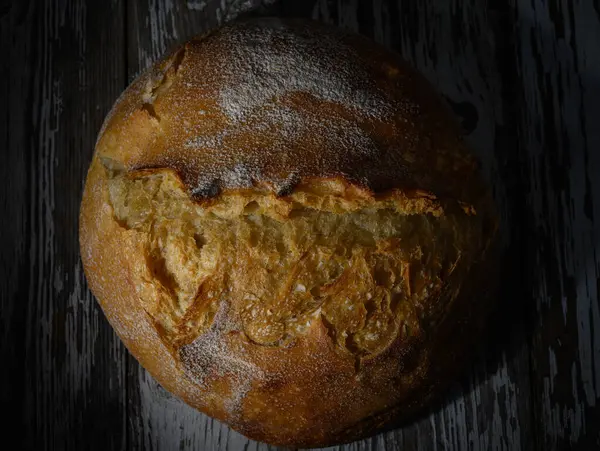Altın kabuklu ekmek hafif ışıkta güneşleniyor, sanatsal dokusunu ve kırsal cazibesini bir anda sergiliyor..