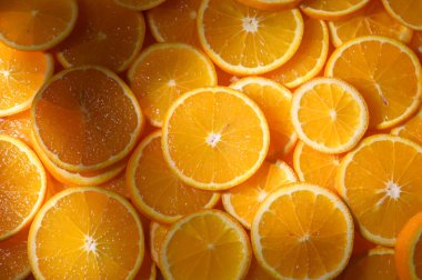 Ilık güneş ışığı altında parlak ve sulu portakal dilimleri, gözler için canlı ve enerjik bir ziyafet yaratır..