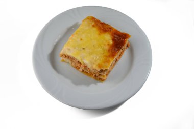 İçten bir lazanya dilimi tabakta duruyor, zengin makarna, et ve erimiş peynir tabaklarını sergiliyor..