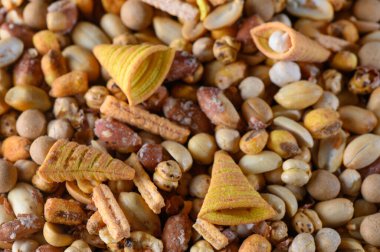 Kıtır kıtır atıştırmalıkların canlı bir karışımı etrafa saçılmış çeşitli şekil ve tatları sergiliyor. Paylaşım için mükemmel..