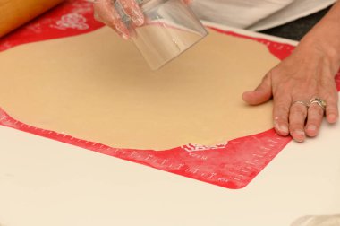 Eller hamuru bardakla şekillendirir. Parlak ve misafirperver bir mutfakta lezzetli şeyler pişirmeye hazırdır..