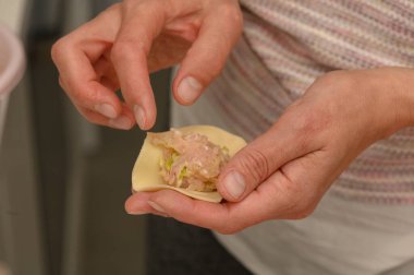 Ellerin becerikli bir şekilde hamur tatlısı hazırlıyor, sıcak ve davetkar bir mutfak atmosferinde yemek pişirme sanatını sergiliyor..