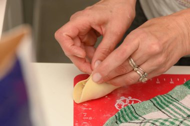 Eller ustalıkla hamuru mükemmel hamur köftelerine katlarken canlı bir mutfak etkinlik ve sıcaklıkla uğulduyor..