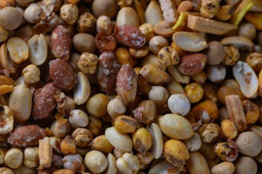 Değişik tohum ve fındıklardan oluşan canlı bir sergi, kırsal bir ahşap masada uzanıyor, doğanın bir pazardaki cömertliğini sergiliyor..