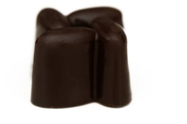 A luscious, dark chocolate piece sits invitingly, showcasing its smooth texture and rich flavor, ready to be savored.