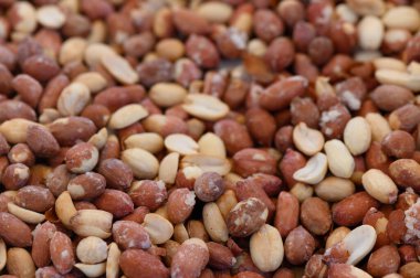 Farklı türde taze biçilmiş fıstıklar gün ortasında hareketli bir pazarda toprak renklerini sergiler..