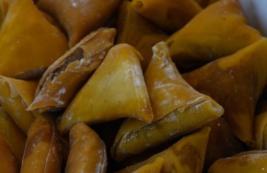 Gün ortası şenliklerinde kalabalık bir açık hava pazarında hevesli misafirleri cazip bir dizi altın samosa bekliyor..