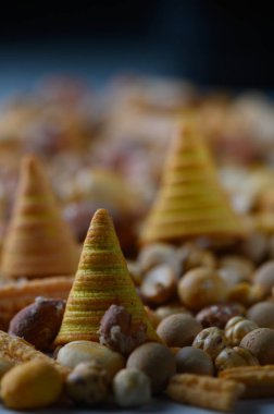 Lezzetli koni ikramı, çeşitli fındık ve çıtır çıtır çerezlerin dağınıklığı arasında, keşif ve zevki davet eden baştan çıkarıcı dokular ve tatlar sergiliyor..