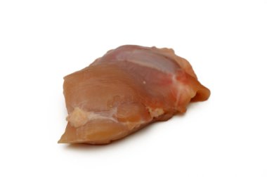 Tek bir çiğ tavuk filetosu beyaz bir yüzeyde duruyor. Lezzetli bir yemeğe dönüşmeye hazır..