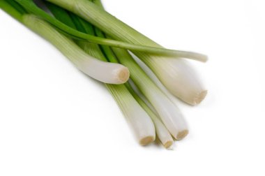 Canlı yeşil soğanlar zarif bir şekilde dizilmiş, gevrekliklerini ve tazeliklerini sergiliyorlar, lezzetli yemekler için mükemmel..