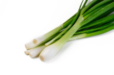 Çıtır çıtır yeşil soğanlar, canlı renklerini ve aşçılık ürünleri için aromatik cazibelerini sergileyerek güzelce düzenlenmiş bir şekilde yatarlar..