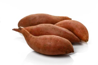 Taze tatlı patatesler, sağlıklı yemek fikirleri için toprak tonlarını ve eşsiz şekillerini vurgulayarak bir araya getirilir..