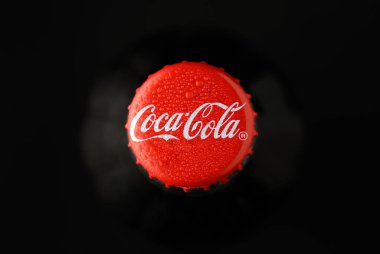 Gaziveren Kıbrıs Rum Kesimi -08.03.2025 Coca Cola Su boncuklarıyla kaplanmış canlı kırmızı bir soda başlığı karanlıkta parlıyor, susuzluğu ve nostaljiyi davet ediyor.