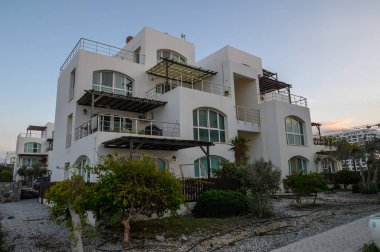 Güzel, çağdaş bir villa, temiz hatlarını ve zarif mimarisini akşam yemyeşil ortamında sergiliyor..