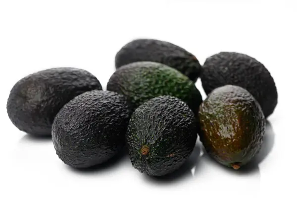 Olgun avokadoların canlı bir koleksiyonu parlak bir arka plana dayanır. Lezzetli tarifler ve sağlıklı yiyecekler sunar..