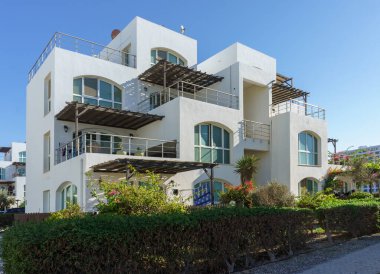 Tropikal bitkilerin arasına yerleşmiş, sakin bir sahil yaşam tarzını yansıtan modern mimarisi olan çarpıcı bir villa..