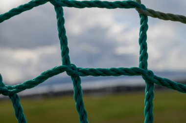 Turkuaz ağ, hafif bir esintiye karşı koyuyor. Bulanık doğal bir arka planda sakin bir atmosfer yaratıyor..