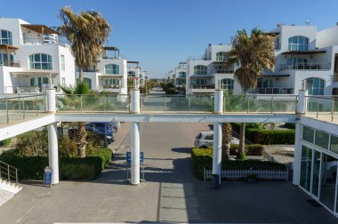 Bu canlı kıyı topluluğu güneşli bir gökyüzünün altında çağdaş mimari ve palmiye ağaçlarını barındırıyor..