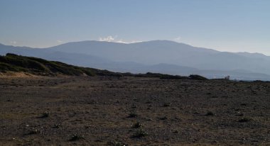 Manzara, batmadan hemen önce doğanın dinginliğini yakalayan yuvarlak tepeler ve geniş bir alana sahiptir..