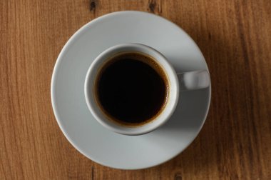 Koyu bir kahve fincanından yavaşça yükselen buhar öğleden sonra molasında sıcaklık ve rahatlık hissi verir..