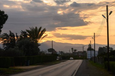 Gökyüzünü altın renkleri aydınlatır. Hava karardığında yemyeşil yollarda esen sessiz bir yol gibi..