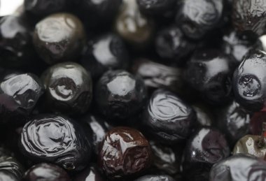 Siyah zeytinler çiğ taneleriyle parıldarlar. Şafak vakti toplandıktan sonra zengin dokularını ve canlı renklerini sergilerler..