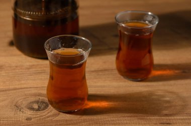 İki hassas bardak buharda pişmiş çay, ahşap bir masada zarifçe oturur, rahatlamaya ve sıcaklığa davetiye çıkarır..