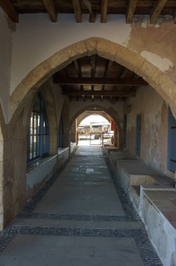 Taş kemerlerle bezenmiş pitoresk koridorda dolaş, ötesinde tuhaf bir avlu ortaya çıkar..