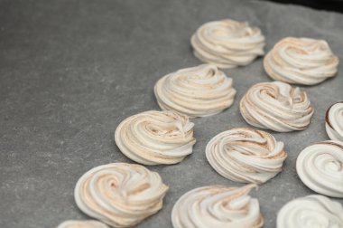 Zarif kremalar parşömen üzerinde dinleniyor, güzel girdaplarını sıcak ve davetkar bir mutfak ortamında sergiliyorlar..