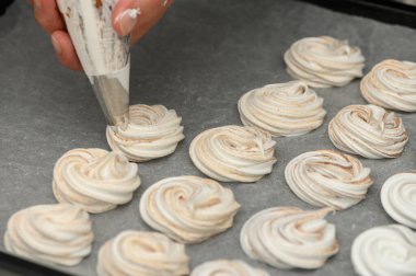 Becerikli bir fırıncı boruları parşömen kağıdında güzel kremalar, sıcak bir mutfakta enfes bir ziyafet yaratıyor..