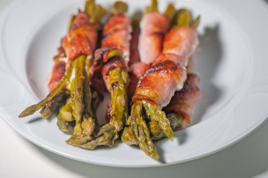 Çıtır domuz pastırması taze kuşkonmaz mızraklarını sarar ve her an duyuları keyiflendiren lezzetli bir yemek yaratır..