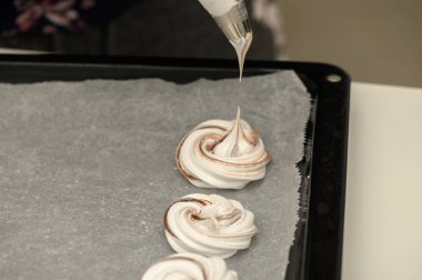 Pasta şefi ustalıkla kağıt üzerinde güzel kıvrımlar yaparak nefis bir tatlıya hazırlanıyor..