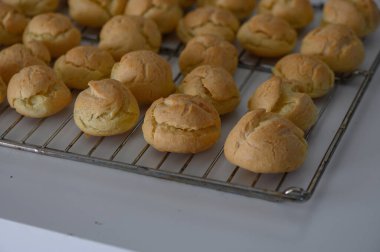 Yumuşak, altın kremalı puflar serinletici bir rafta dinleniyor, ev gibi bir mutfak atmosferinde enfes kokular yayıyor..