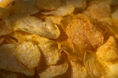 Taze kızarmış patates cipsleri, güneşli bir günde çıtır çıtır çerezlerinin tadını çıkarmaları için onları davet eder..