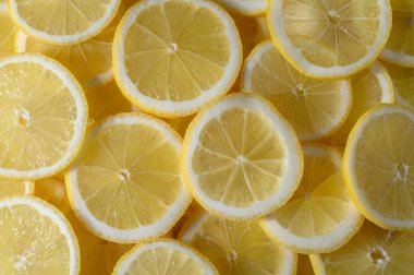 Limon dilimleri, içeceklere ve yemeklere lezzet katmak için mükemmel olan sulu, sarı iç kısımlarını sergiliyor..