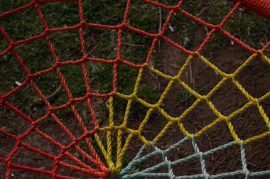 Canlı renkli ağlar yumuşak çimenlerin üzerinde uzanır, açık hava aktiviteleri ve oyunlar için eğlenceli bir zemin oluşturur.