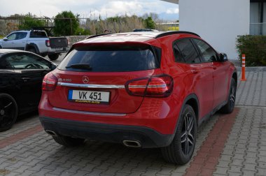 Gaziveren Kıbrıs Rum Kesimi -03.03.2025 çarpan kırmızı bir SUV, bulutlu bir zemin karşısında çağdaş tasarımını sergileyerek, parlak siyah bir aracın yanında duruyor..